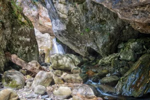 landschapsfotografie - Towering Sass Corbée rock formation in Val Sanagra, ancient Carboniferous boulder dominating a forested valley landscape